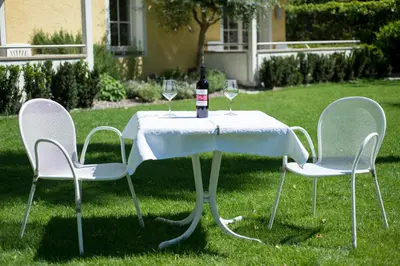 a table with two chairs and a bottle of wine at Apartments Villa Majense in Merano