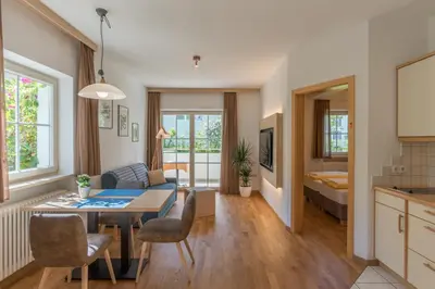 a kitchen and living room with a table and chairs at Apartments Villa Majense in Merano