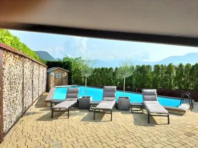 a patio with chairs and a table and a swimming pool at Melanies Guesthouse 2 Zimmerwohnung in Caldaro