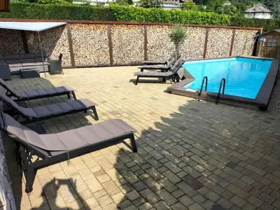 a patio with lounge chairs and a swimming pool at Melanies Guesthouse 2 Zimmerwohnung in Caldaro