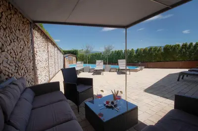 a patio with a couch and chairs and a table at Melanies Guesthouse 2 Zimmerwohnung in Caldaro
