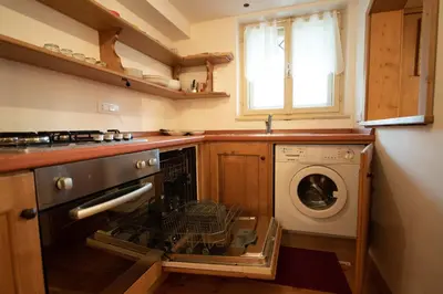 a kitchen with an open oven with a dishwasher at FALORIA Studio Apartment in Cortina dʼAmpezzo