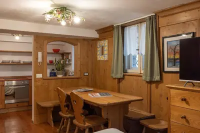 a dining room with a wooden table and chairs at FALORIA Studio Apartment in Cortina dʼAmpezzo