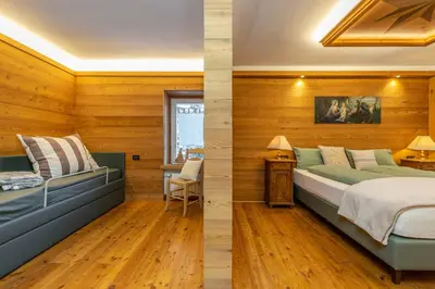 two images of a bedroom with wooden walls and a bed at Rifugio Cereda in Fiera di Primiero