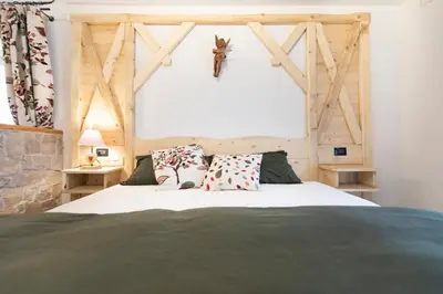 a bedroom with a large bed with a wooden wall at Rifugio Cereda in Fiera di Primiero