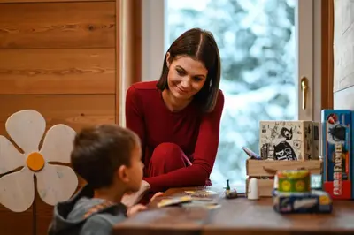 a woman sitting at a table with a little boy at Rifugio Cereda in Fiera di Primiero