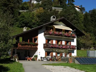 a white house with flowers on the balconies at Apartment Furschermuehle in Siusi
