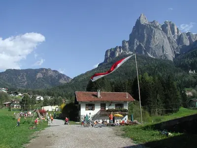 a red and white flag flying in front of a house at Apartment Furschermuehle in Siusi