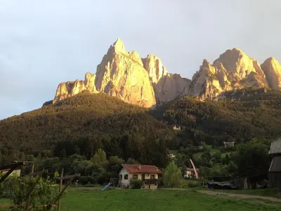 a mountain range with a house in a field at Apartment Furschermuehle in Siusi