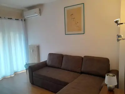 a living room with a couch and a picture on the wall at Appartamento ospitale in Bolzano