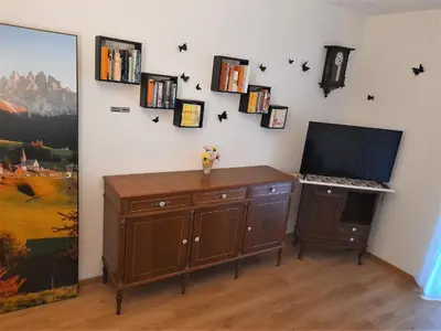 a room with a desk with a tv on a wall at Appartamento ospitale in Bolzano