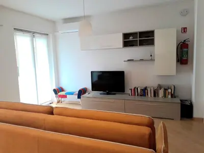 a living room with a couch and a tv at Appartamento ospitale in Bolzano