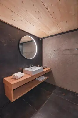 a bathroom with a sink and a mirror at Steindls Boutique Favourite in Vipiteno