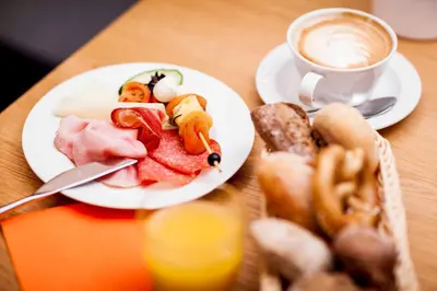 a table with two plates of food and a cup of coffee at Steindls Boutique Favourite in Vipiteno