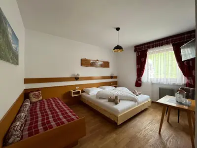 a small bedroom with a bed and a table at Pension Hatzis in Laion