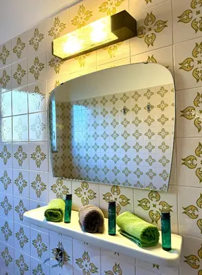 a bathroom with a sink with a mirror and towels at Pension Hatzis in Laion