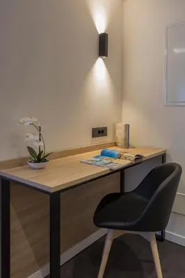 a desk with a chair and a light on top at Tourist Hotel in Bressanone