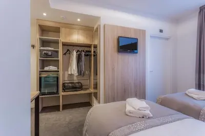 a bedroom with two beds and a closet at Tourist Hotel in Bressanone