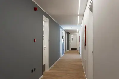 a long hallway with white walls and wood floors at Tourist Hotel in Bressanone