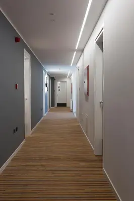 a corridor of an office with white walls and a long hallway at Tourist Hotel in Bressanone