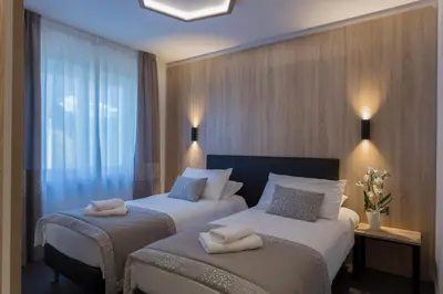 a hotel room with two beds with towels on them at Tourist Hotel in Bressanone