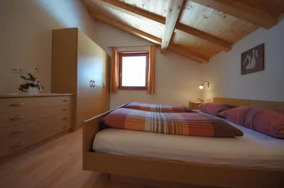 a bedroom with a bed and a dresser and a window at Pastrogn 4 in La Valle