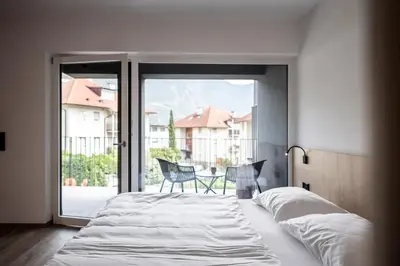 a bedroom with a bed and a sliding glass door at Sambucus Apartments -Premium Apartments for You and Your Dog in Lana