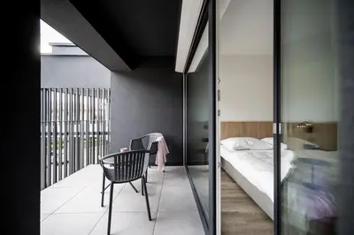 a room with a bed and a chair and a table at Sambucus Apartments -Premium Apartments for You and Your Dog in Lana