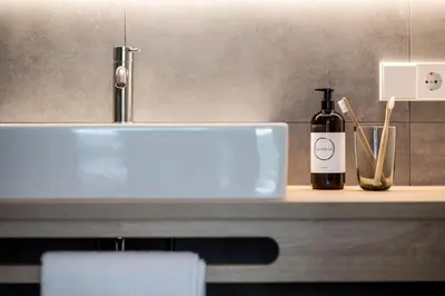 a bottle of wine sitting on a counter next to a sink at Sambucus Apartments -Premium Apartments for You and Your Dog in Lana