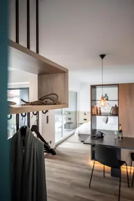 a bedroom with a bed and a desk and a table at Sambucus Apartments -Premium Apartments for You and Your Dog in Lana