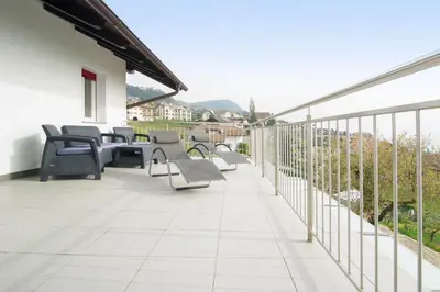 a patio with chairs and tables on a balcony at Zum Schwarzen Kus in Caldaro