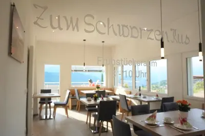 a restaurant with tables and chairs and a view of the ocean at Zum Schwarzen Kus in Caldaro
