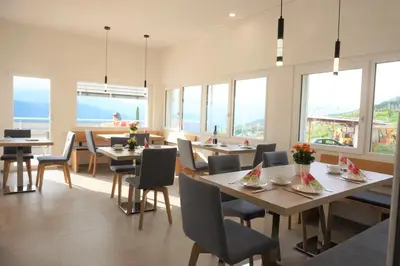 a dining room with tables and chairs and windows at Zum Schwarzen Kus in Caldaro