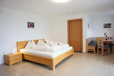 a bedroom with a bed with a table and a dining room at Zum Schwarzen Kus in Caldaro