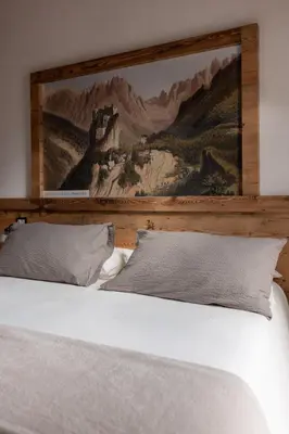 a bedroom with a bed with a painting on the wall at Hotel Cant del Gal in Fiera di Primiero