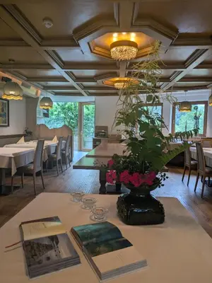 a dining room with a table with a plant on it at Hotel Alpenblick in Sarntal