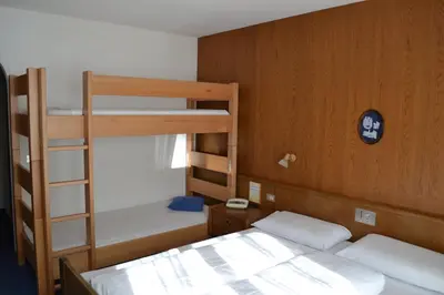 a bedroom with two bunk beds and a ladder at Hotel Alpenblick in Sarntal