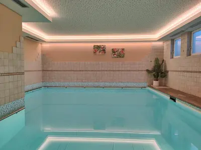 a swimming pool in a house with a large swimming pool at Hotel Alpenblick in Sarntal