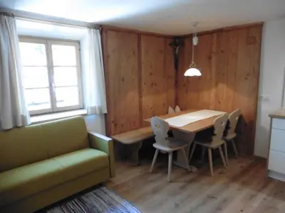 a dining room with a table and chairs and a couch at Obergereuth Hof 1288 in San Martino