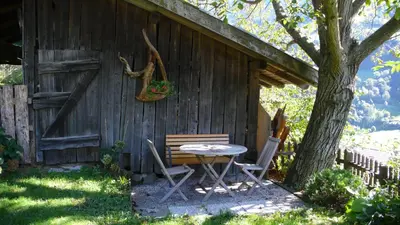 a table and chairs sitting outside of a cabin at Obergereuth Hof 1288 in San Martino