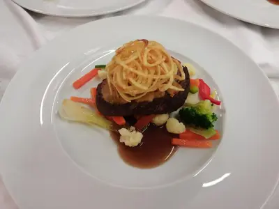 a plate of food with pasta and vegetables on a table at Sport Hotel Cristal in Falcade