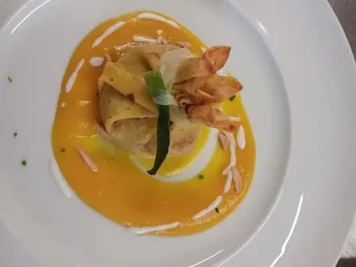 a plate of food with shrimp in a yellow sauce at Sport Hotel Cristal in Falcade