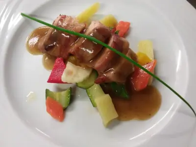 a plate of food with meat and vegetables on it at Sport Hotel Cristal in Falcade