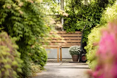 a bench and a table in a garden at Garden Residence in Lana