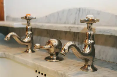 two bronze faucets on a counter in a bathroom at Hotel Lago di Braies in Braies
