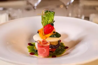 a dish on a white plate with food on it at Hotel Lago di Braies in Braies