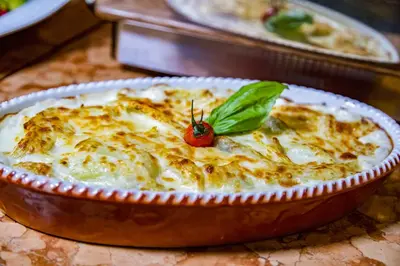 a casserole dish of food with a tomato on top at Hotel Lago di Braies in Braies
