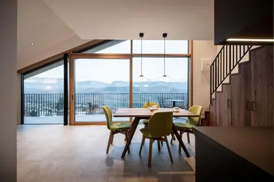 a dining room with a table and chairs and a large window at Papstlhof in Caldaro