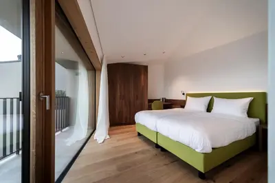 a bedroom with a bed with a green headboard at Papstlhof in Caldaro