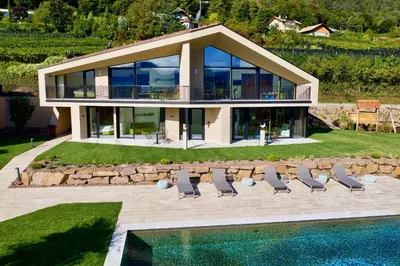 a house with chairs and a swimming pool at Papstlhof in Caldaro